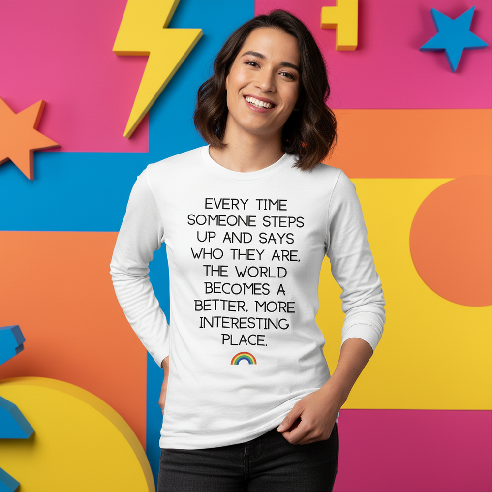 Smiling model in a white long-sleeve shirt with a quote and small rainbow graphic
