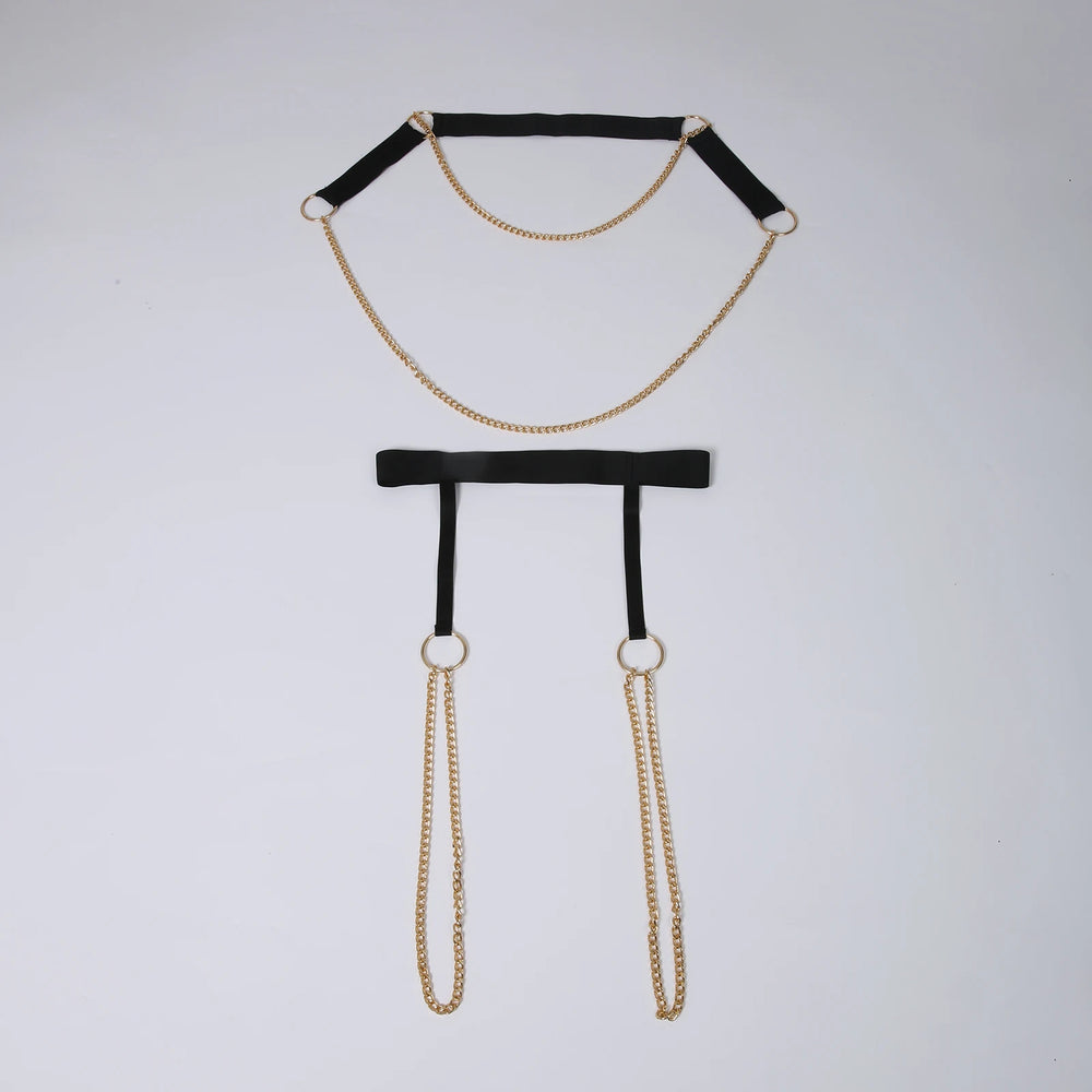 Flat-lay black chain harness with gold-tone rings and dangling chains