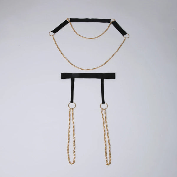 Flat-lay black chain harness with gold-tone rings and dangling chains