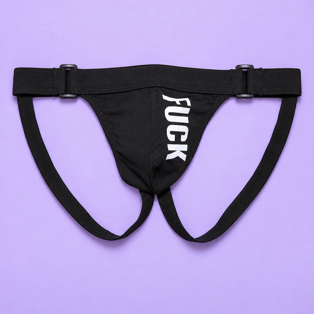 Black F#CK jockstrap laid flat on lavender, with vertical white lettering, adjustable waistband and two rear straps.