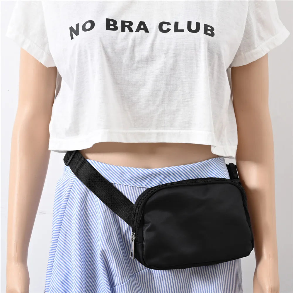 Black rectangular fanny pack worn crossbody over a blue-and-white striped skirt