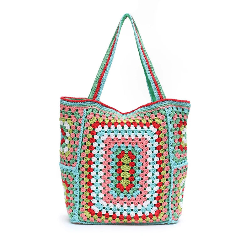 Front-facing crocheted tote bag with colorful granny-square pattern and two long handles