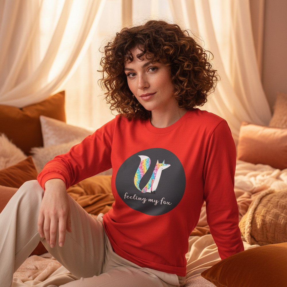 Feeling My Fox Unisex Long Sleeve T-Shirt with a vibrant fox and “feeling my fox” slogan, worn on a bed with tan
