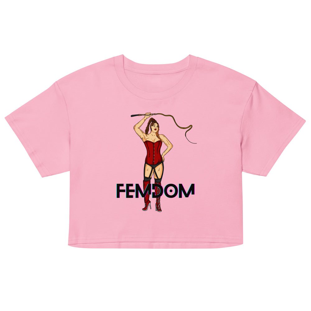 Front view of a pink crop top reading “FEMDOM,” with a corset-clad woman holding a whip