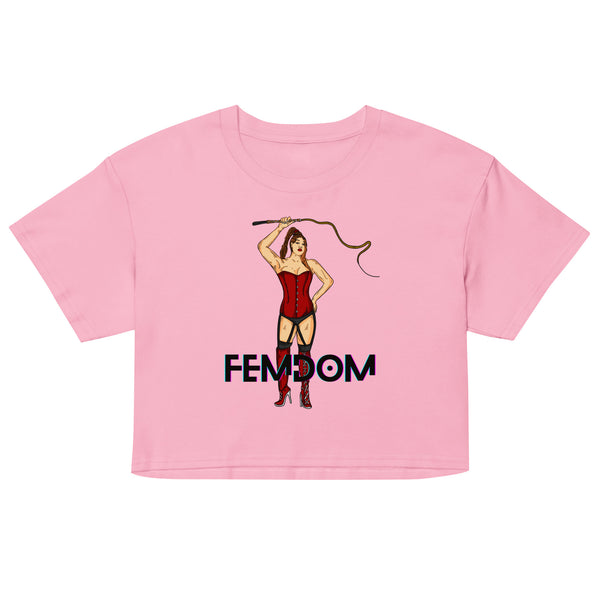 Front view of a pink crop top reading “FEMDOM,” with a corset-clad woman holding a whip