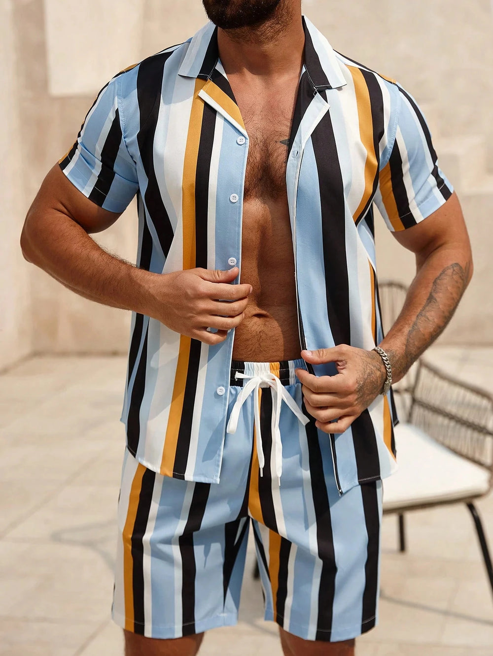Model wearing Santorini Heatwave two-piece set with blue, yellow, white and black vertical stripes outdoors