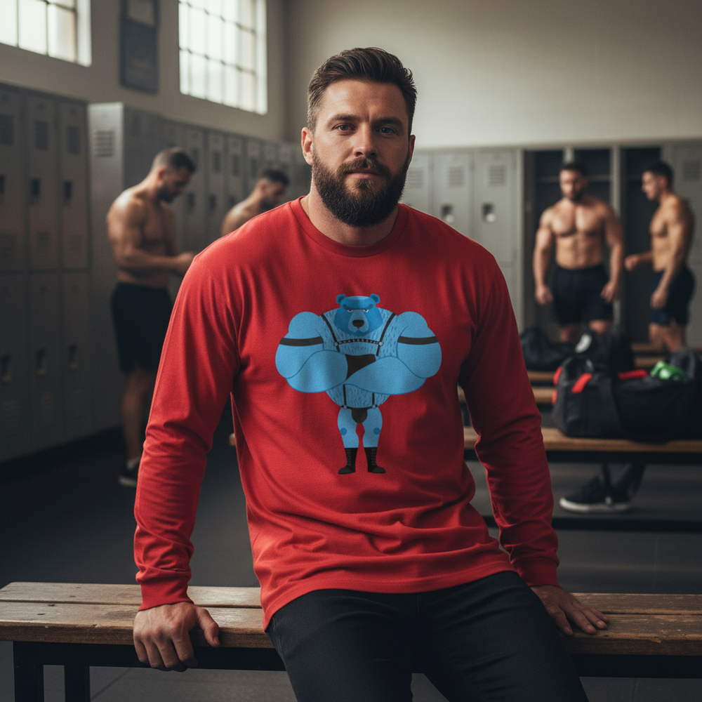 Unisex long sleeve red Fetish Gay Bear tee with muscular blue cartoon bear, worn by a bearded person on a gym bench