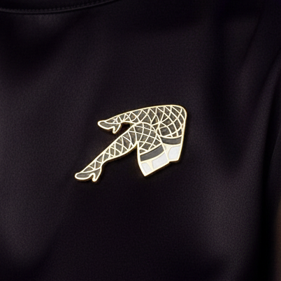 Fishnet Stockings Enamel Pin: A gold-tone brooch shaped like a leg in fishnet stockings and a garter