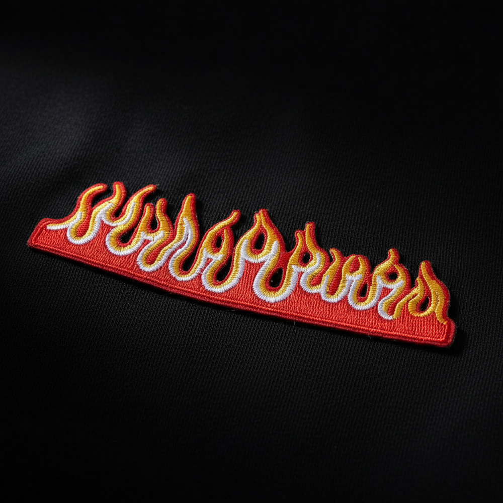 Embroidered flame patch with red, yellow, and white flames on black fabric
