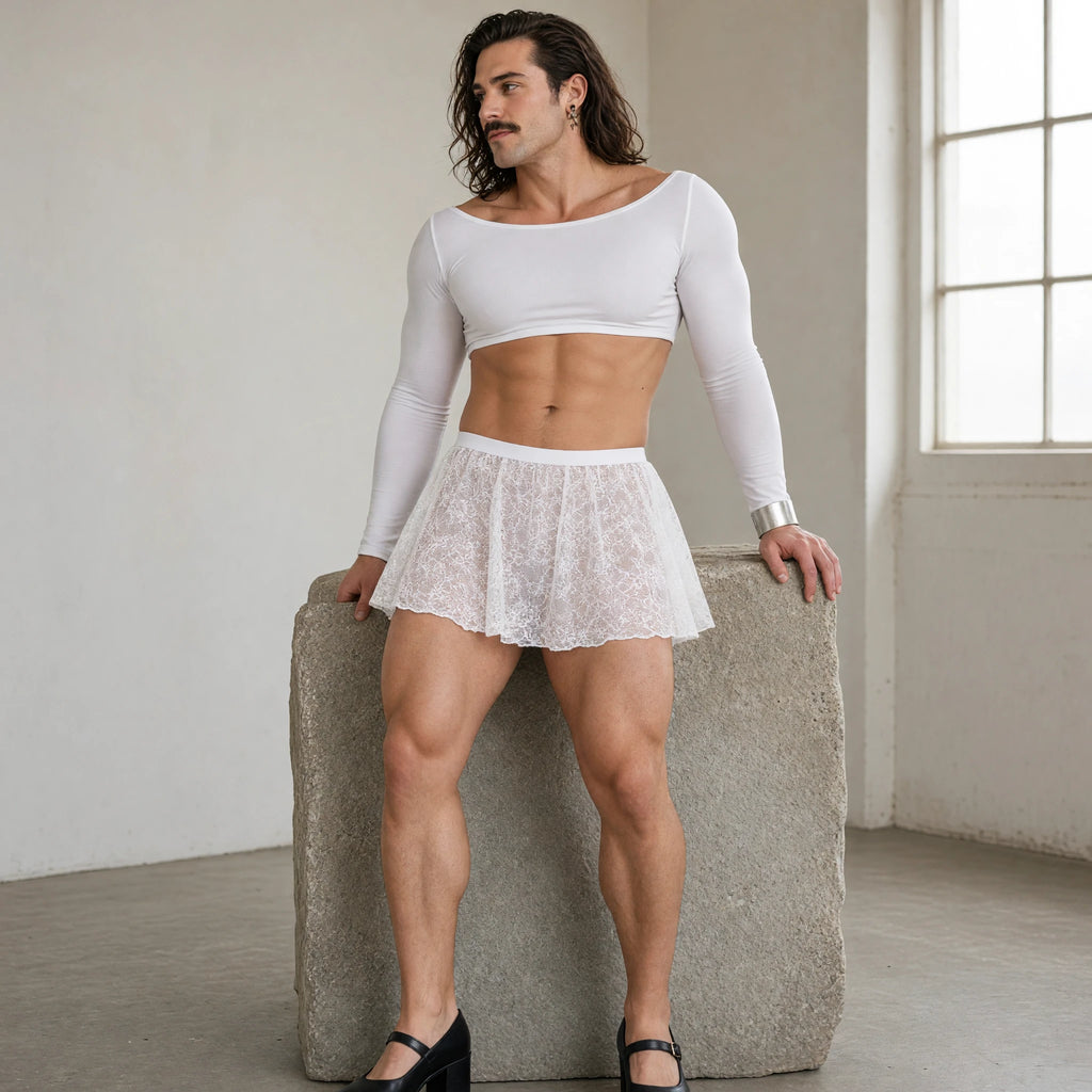 Model wearing a white floral lace mini skirt over opaque shorts with a white crop top in a sculpture studio