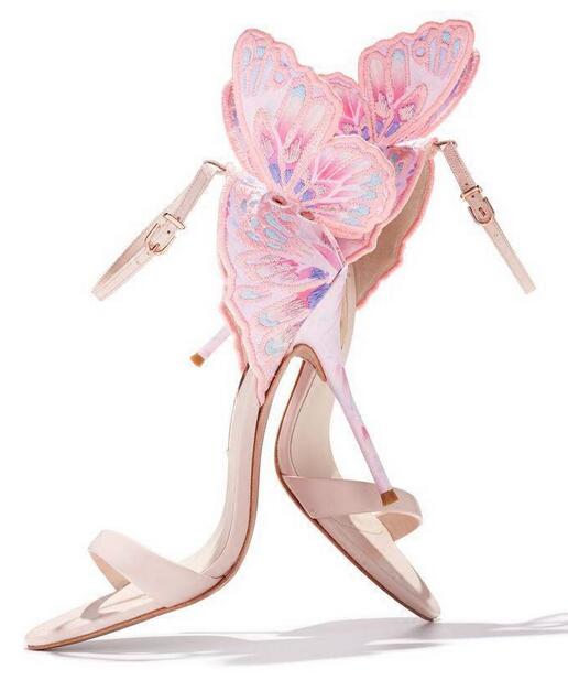 Pair of pink butterfly-wing high-heeled sandals shown at an angled rear view