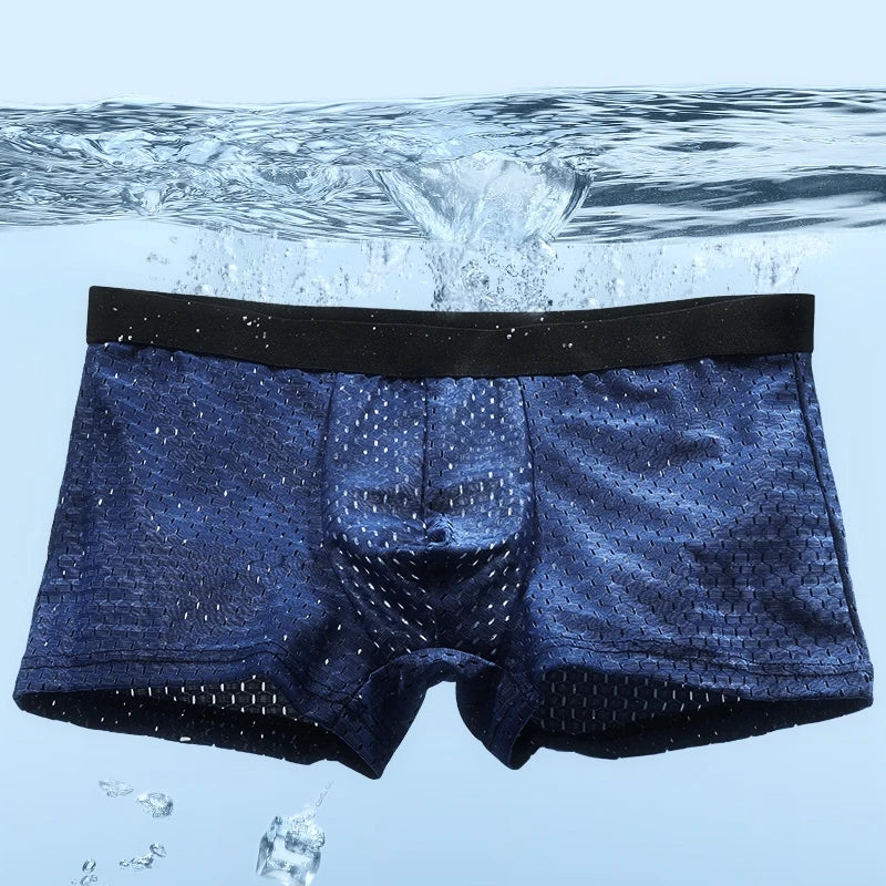 Front view of navy blue boxer briefs suspended underwater with bubbles