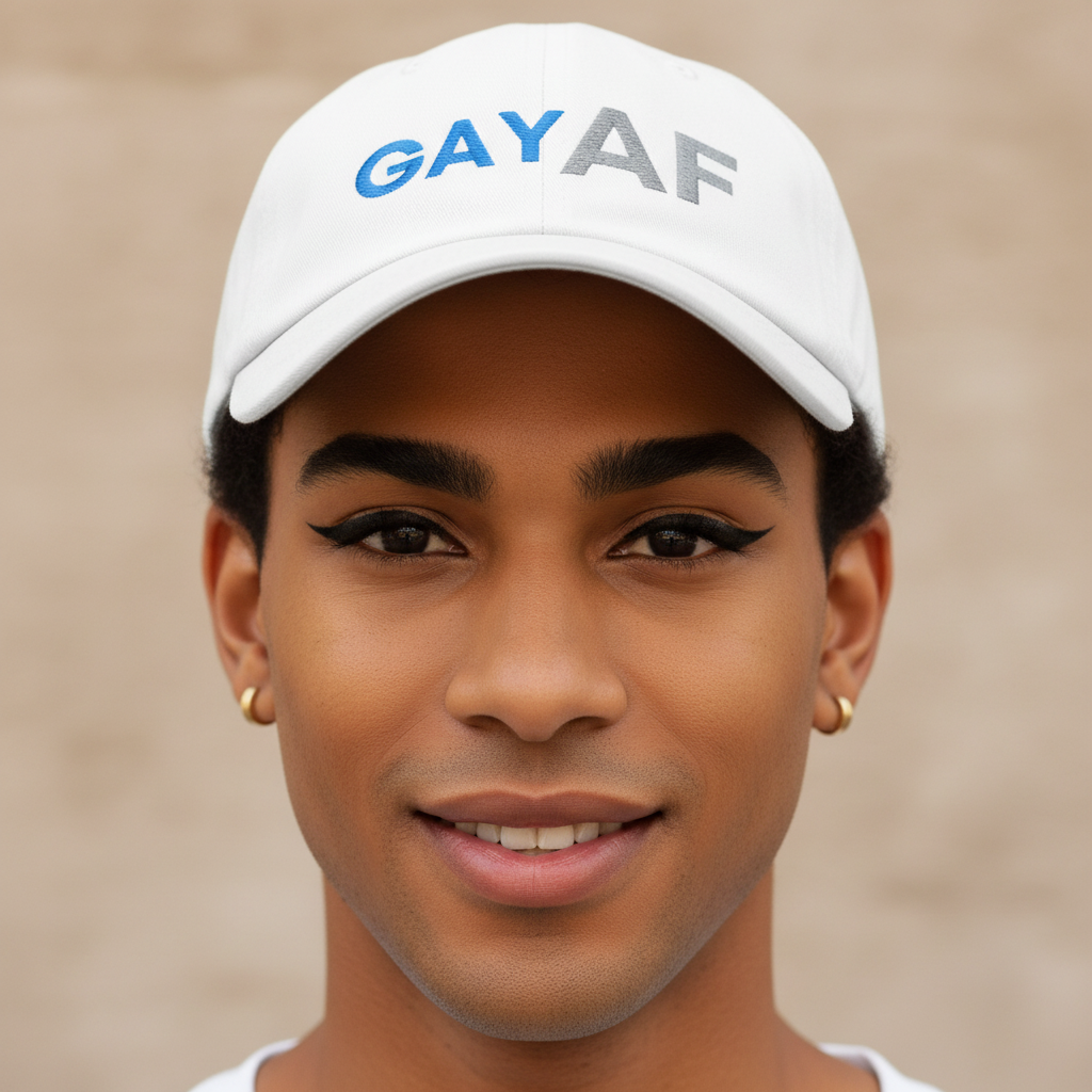 Gay AF Cap—a classic white hat with "GAY AF" embroidered in blue and gray—modeled by a young, dark-skinned queer person.