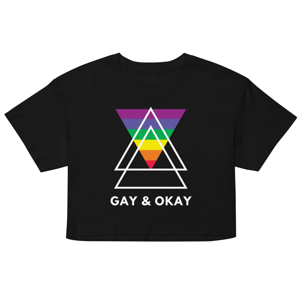 Gay & Ok Crop Top with rainbow triangle and "Gay & Okay" slogan, worn on a lively night street draped in LGBTQ+ rainbow flags.