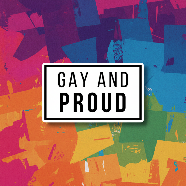 White rectangular magnet reading “GAY AND PROUD” over colorful abstract paint strokes