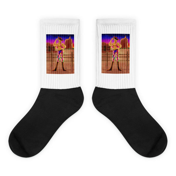 Pair of black-and-white crew socks with colorful cowboy sunset artwork on the cuffs