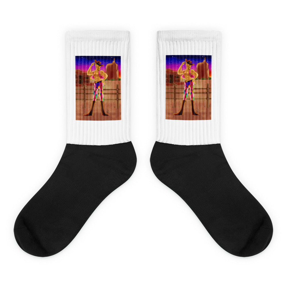 Pair of black-and-white crew socks with colorful cowboy sunset artwork on the cuffs