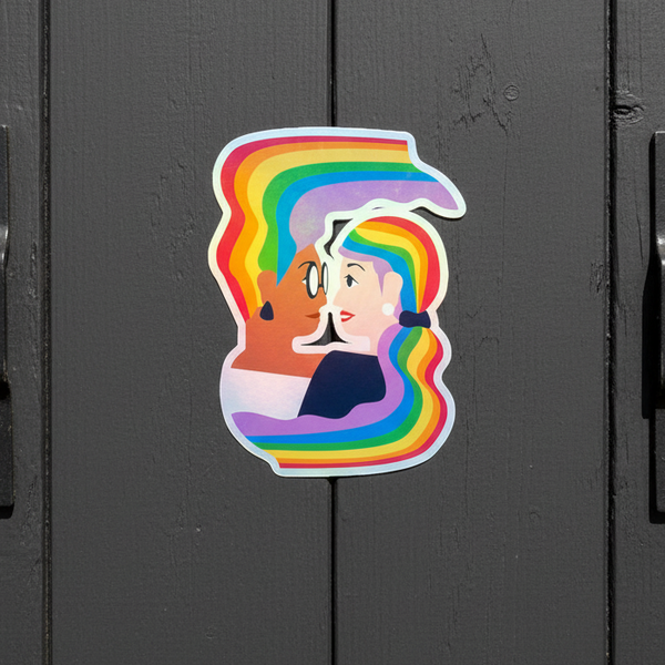 Holographic rainbow sticker of two stylized cowboys kissing on a dark door