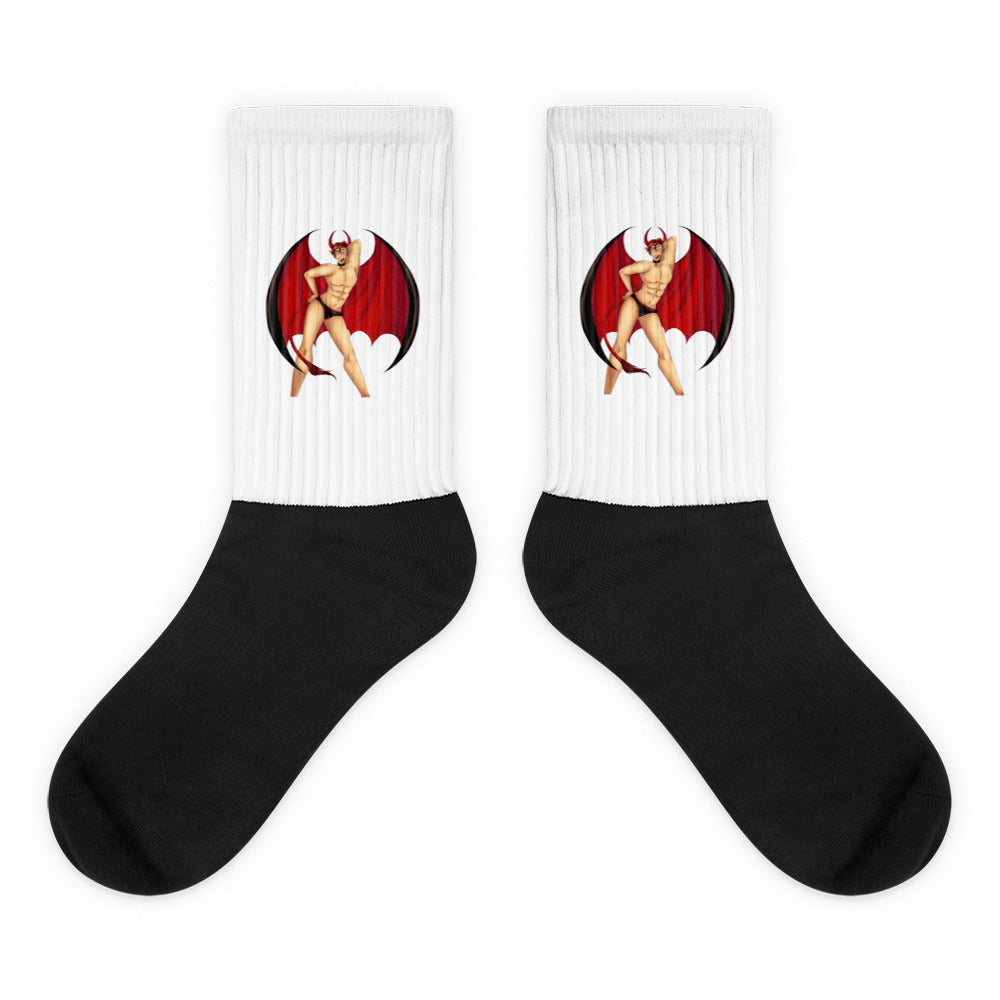 Pair of black socks with white ribbed cuffs showing a red-winged devil pin-up graphic