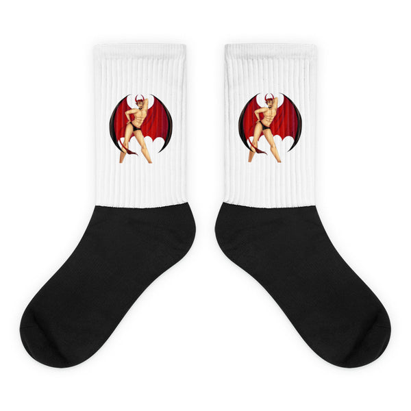 Pair of black socks with white ribbed cuffs showing a red-winged devil pin-up graphic