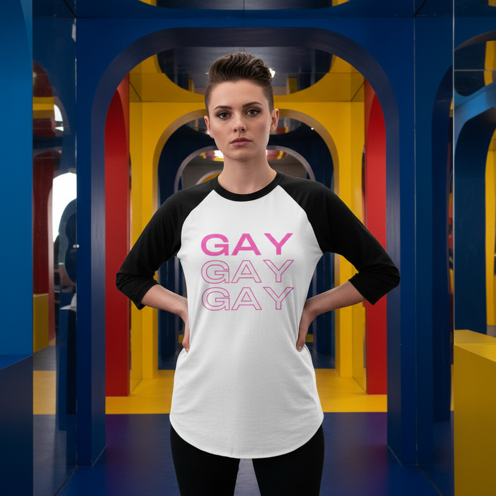 3/4 sleeve raglan shirt with bold pink "GAY GAY GAY" text, worn by a short-haired person in a vivid, rainbow-hued room.