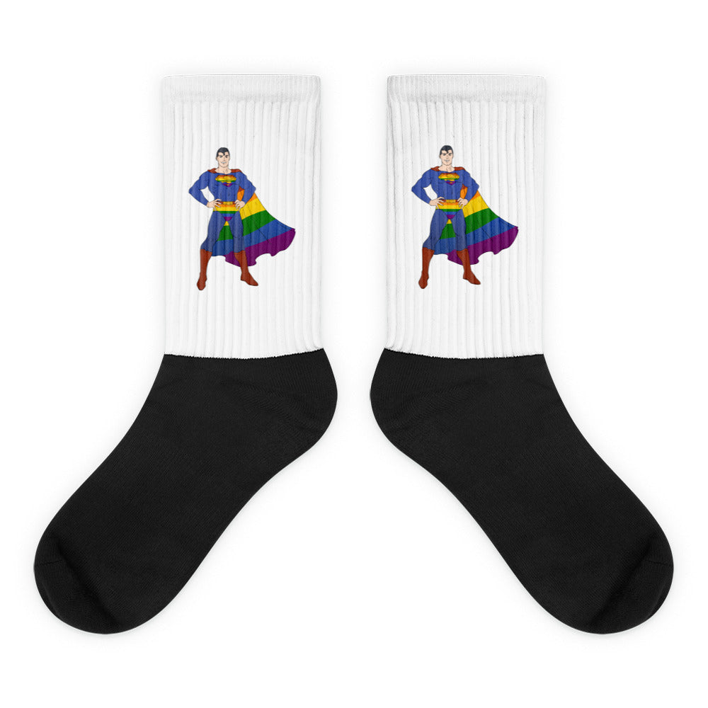 Pair of white ribbed socks with rainbow-caped superhero designs and black feet