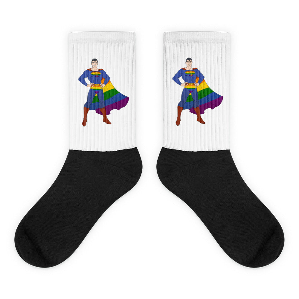 Pair of black-and-white crew socks featuring a superhero in a rainbow cape