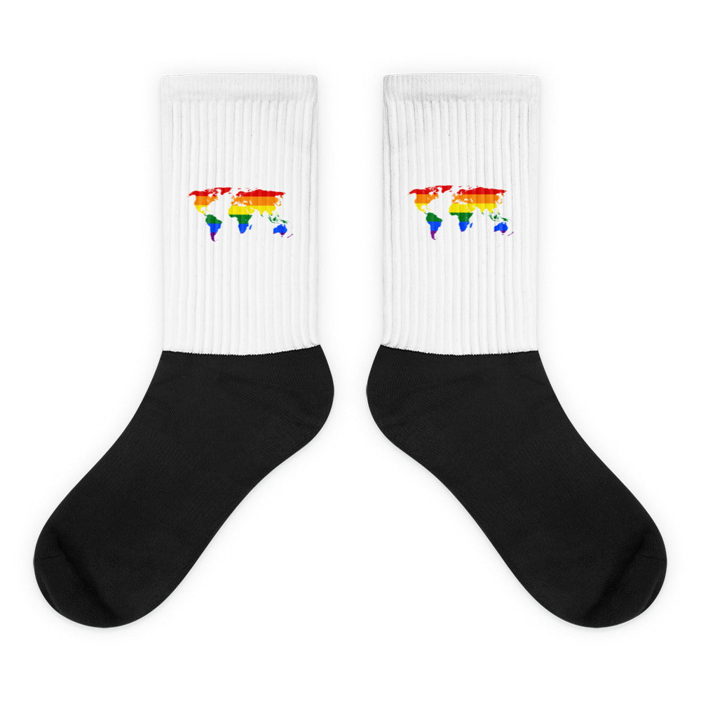 Pair of white-and-black socks with small rainbow-striped world maps on the cuffs