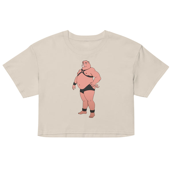 Front view of a beige crop top with a cartoon pig in black harness gear and briefs