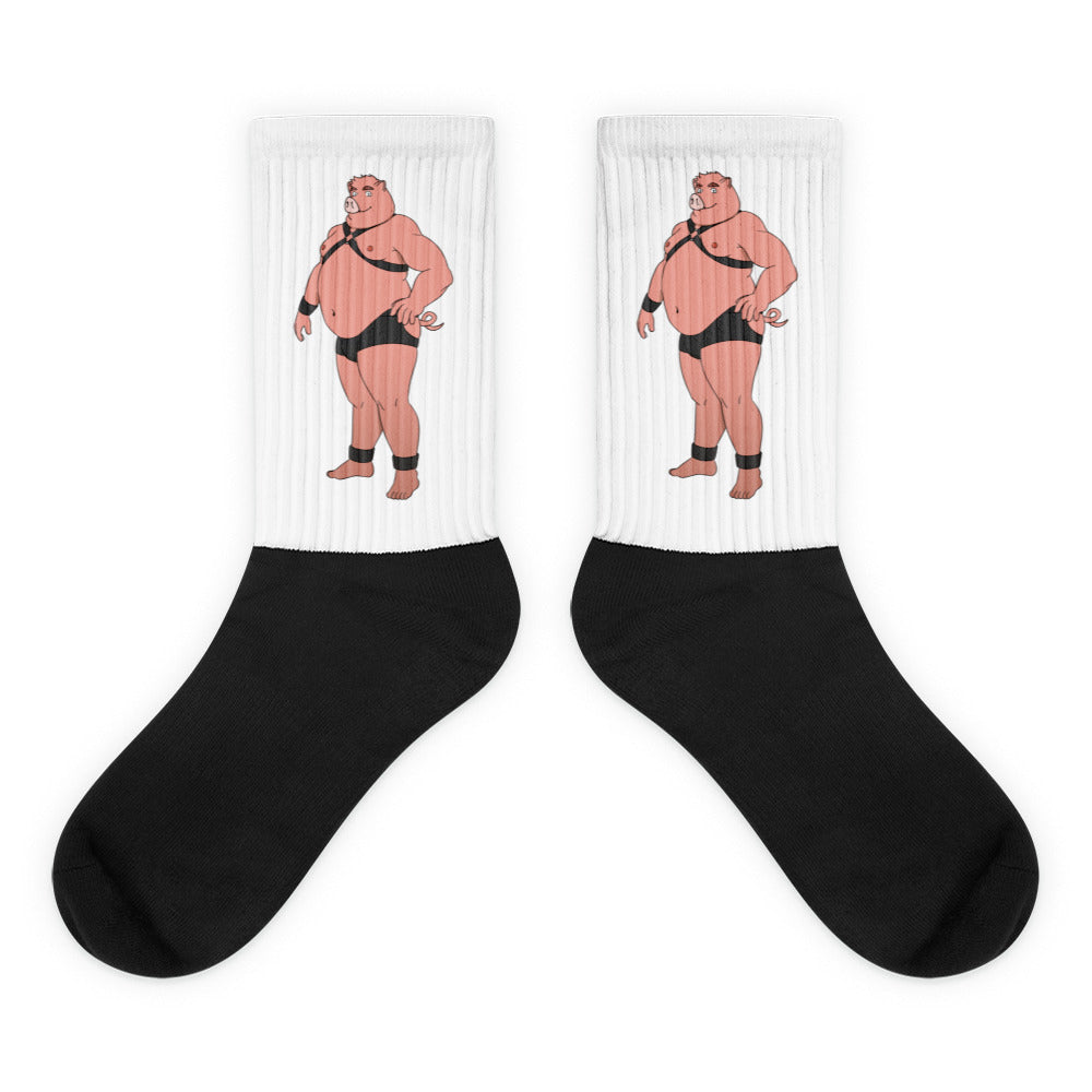 Pair of white and black crew socks with cartoon pigs in leather harnesses