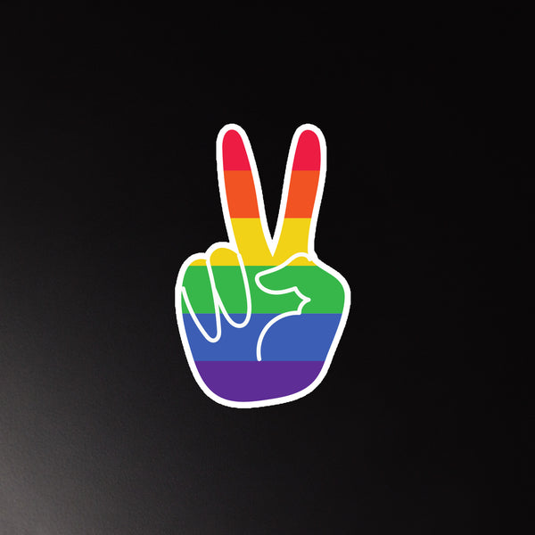 Rainbow-striped hand-shaped magnet showing a peace-sign gesture on a black background