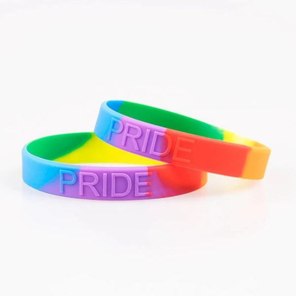 Two overlapping rainbow silicone wristbands embossed with “PRIDE” on a white background