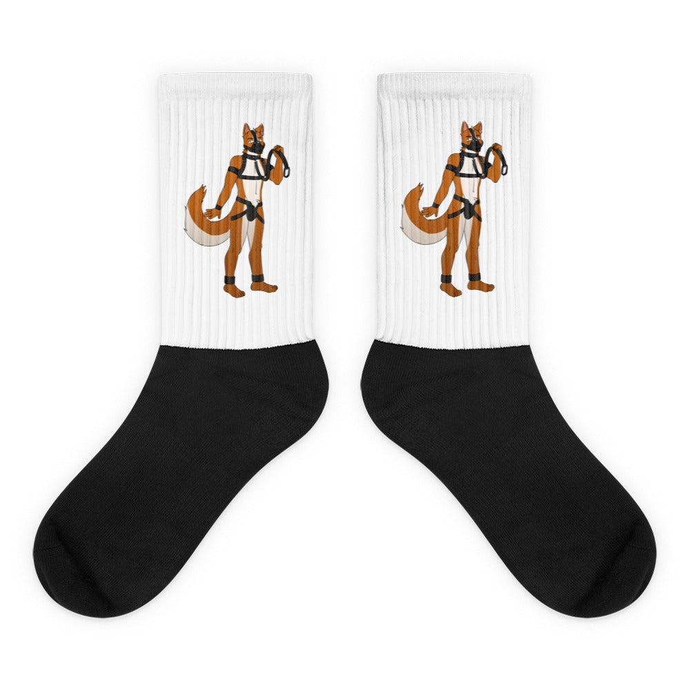 Pair of white ribbed crew socks with orange fox figures in black harnesses and black feet