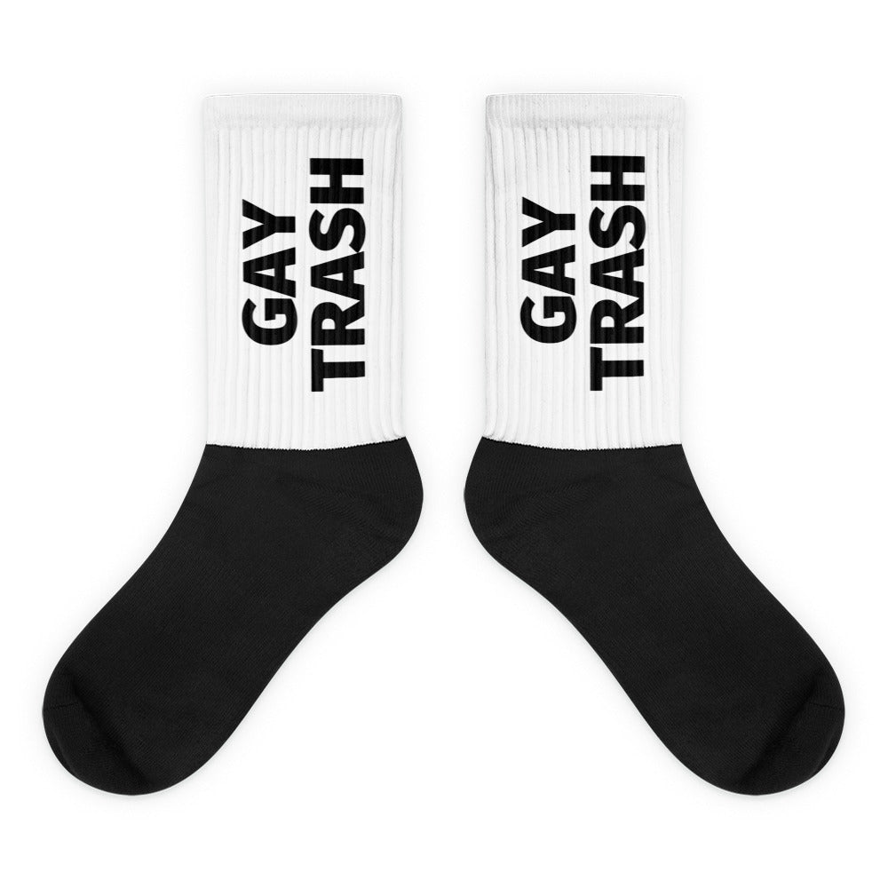 Pair of white-and-black crew socks with bold vertical “GAY TRASH” lettering