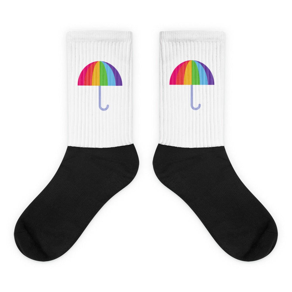 Pair of black-and-white crew socks with rainbow umbrella designs on the ribbed cuffs