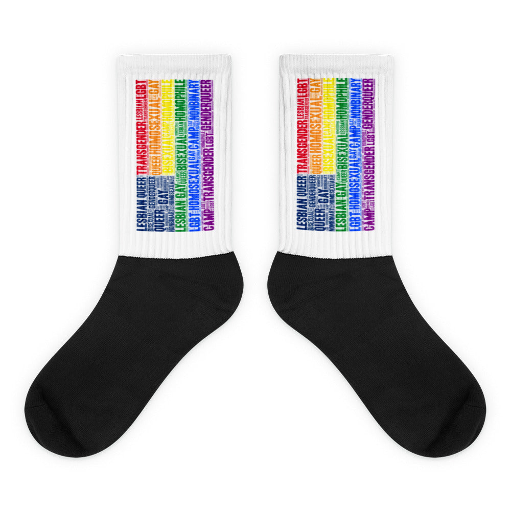 Pair of black socks with white cuffs covered in rainbow LGBTQ+ identity words