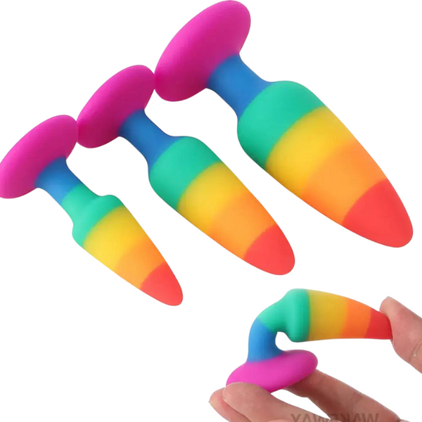 Four rainbow-colored prostate massagers, including one bent in a hand