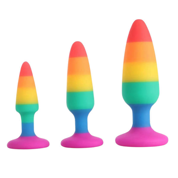 Three rainbow-striped silicone anal plugs in graduated sizes on a white background