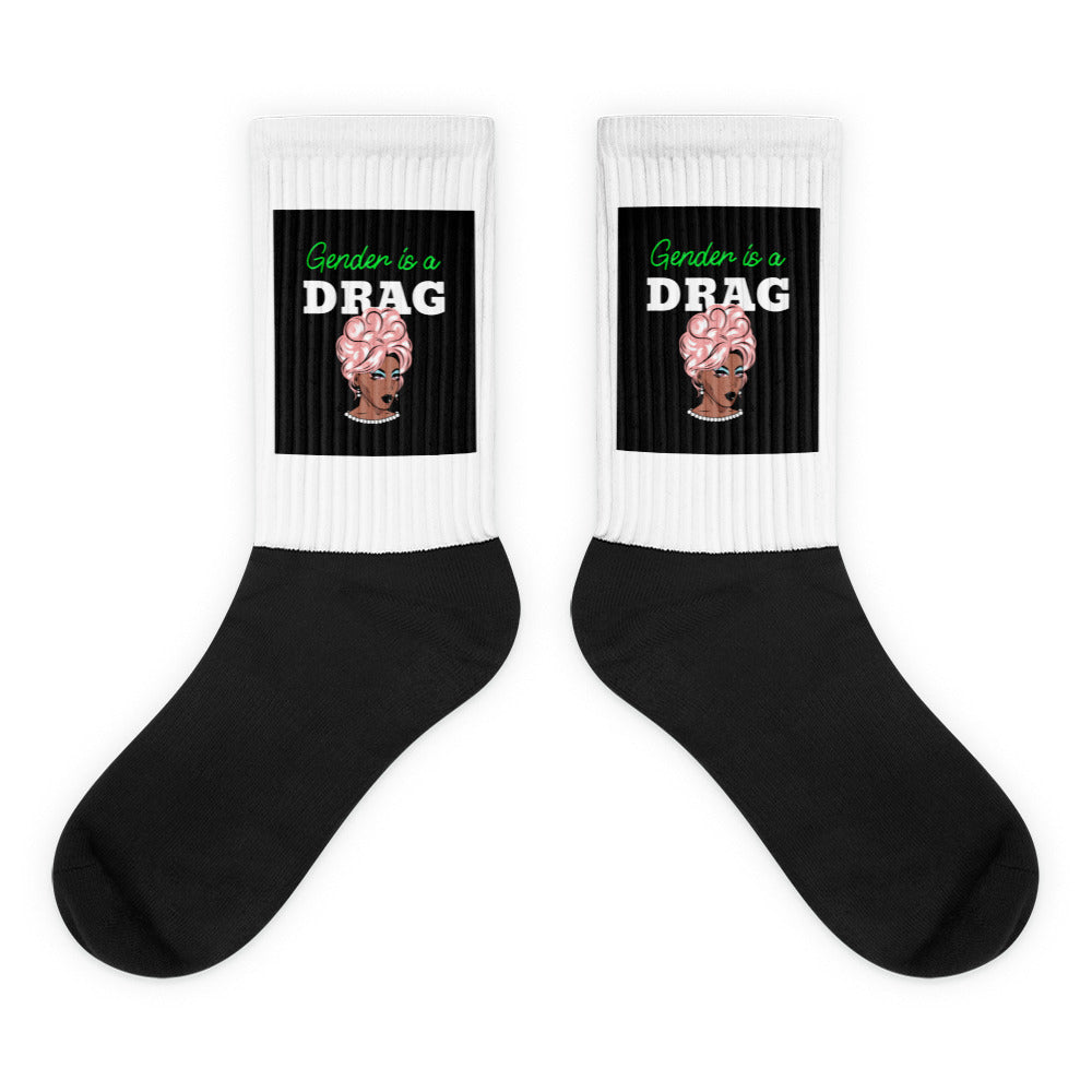 Pair of black-and-white crew socks reading “Gender is a DRAG” with a drag portrait