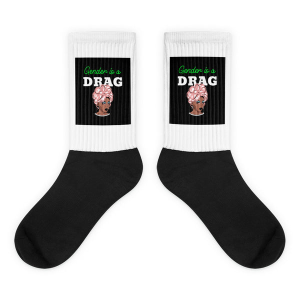Pair of black-and-white crew socks reading “Gender is a DRAG” with a drag portrait
