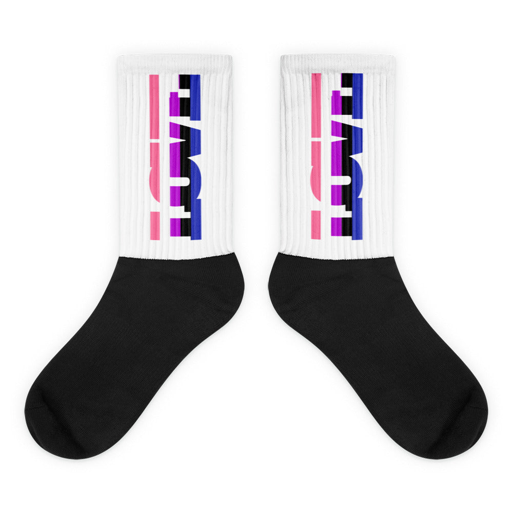 Pair of black-and-white crew socks with pink, purple, and blue block graphics on the cuffs