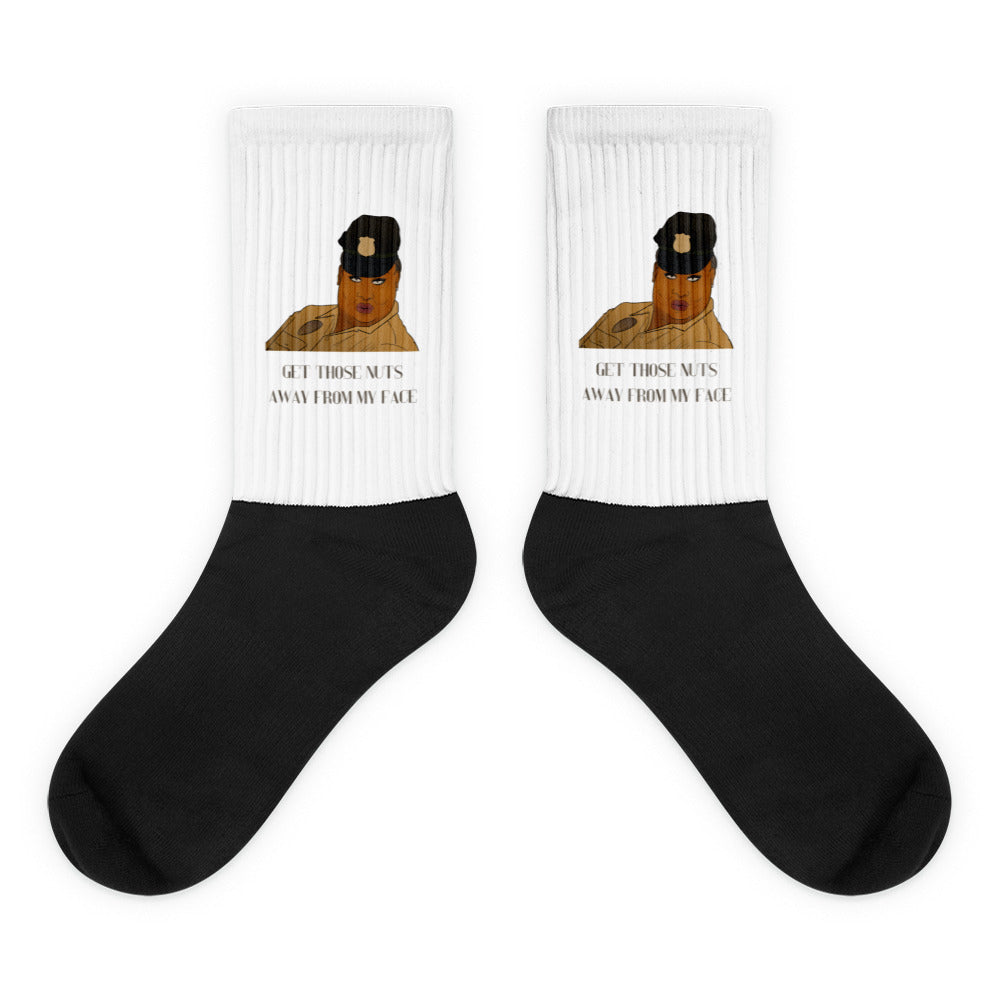 Pair of black-and-white crew socks with a cartoon police officer and “GET THOSE NUTS AWAY FROM MY FACE”