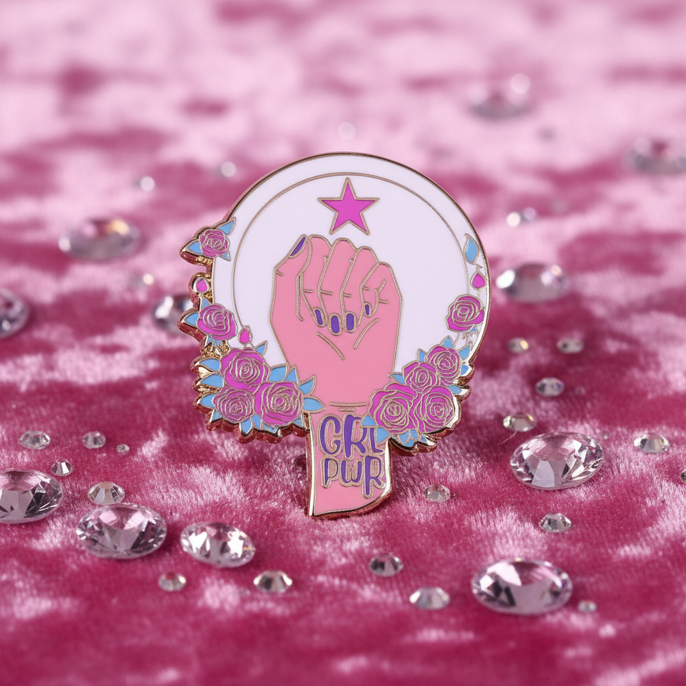 Girl PWR enamel pin with pink raised fist, star, and roses on pink velvet
