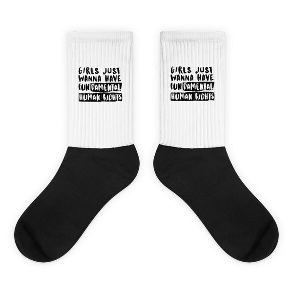 Pair of black-and-white socks reading “GIRLS JUST WANNA HAVE FUNDAMENTAL HUMAN RIGHTS”