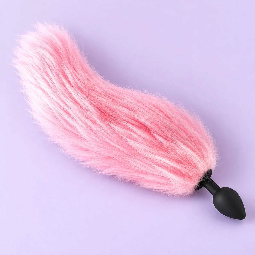 Unlit pink GlowTails furry tail butt plug with a black tapered plug, displayed in full on lavender.