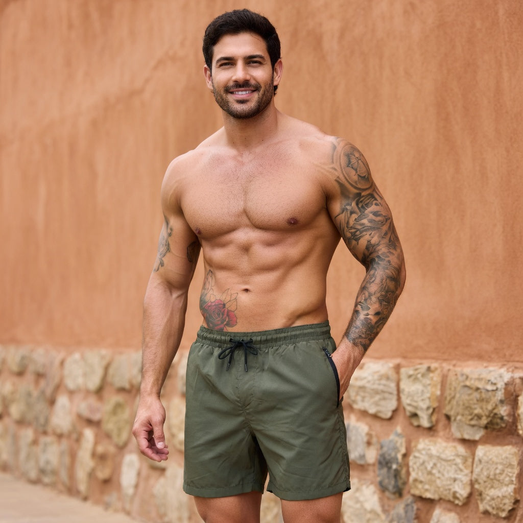 Model wearing green drawstring shorts with zipped side pockets beside a terracotta training wall.