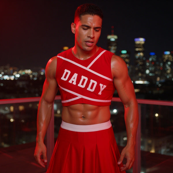 Close-up of a model wearing a red cropped cheerleader top and pleated skirt labeled “DADDY”