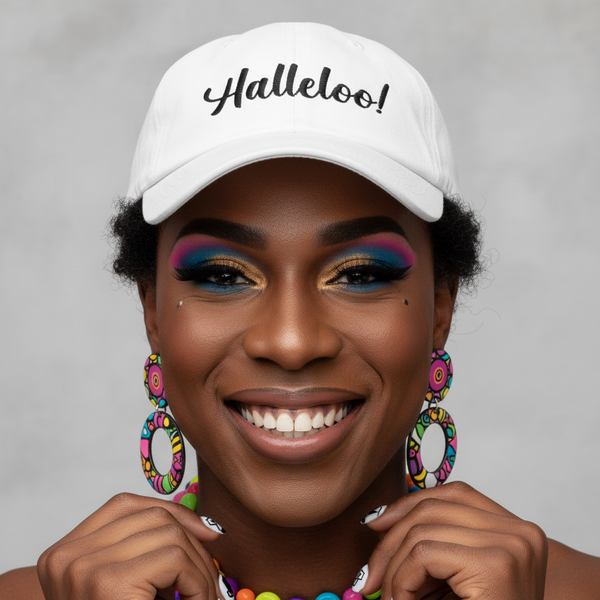 The Halleloo! Cap tops a dark-skinned, smiling queer babe with bright earrings, vivid makeup