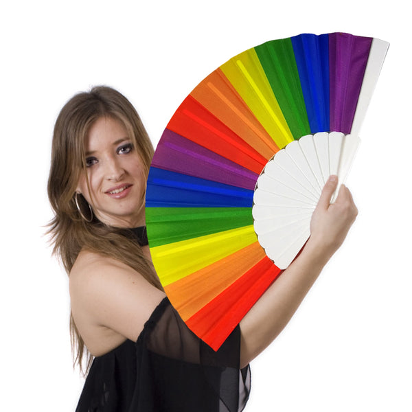 Person holding an open rainbow folding fan with white ribs against a white background
