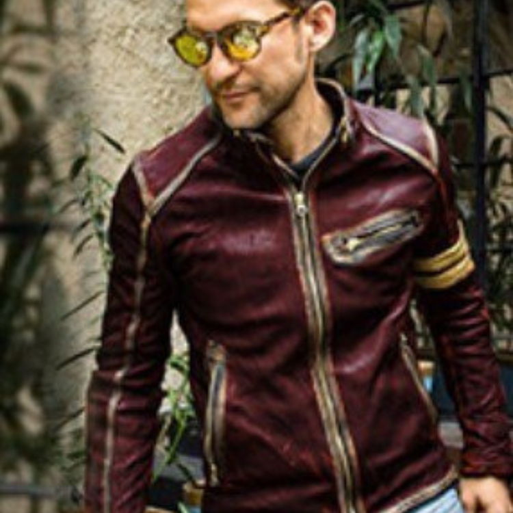 Person modeling a burgundy biker jacket with gold zippers and an upper-arm stripe
